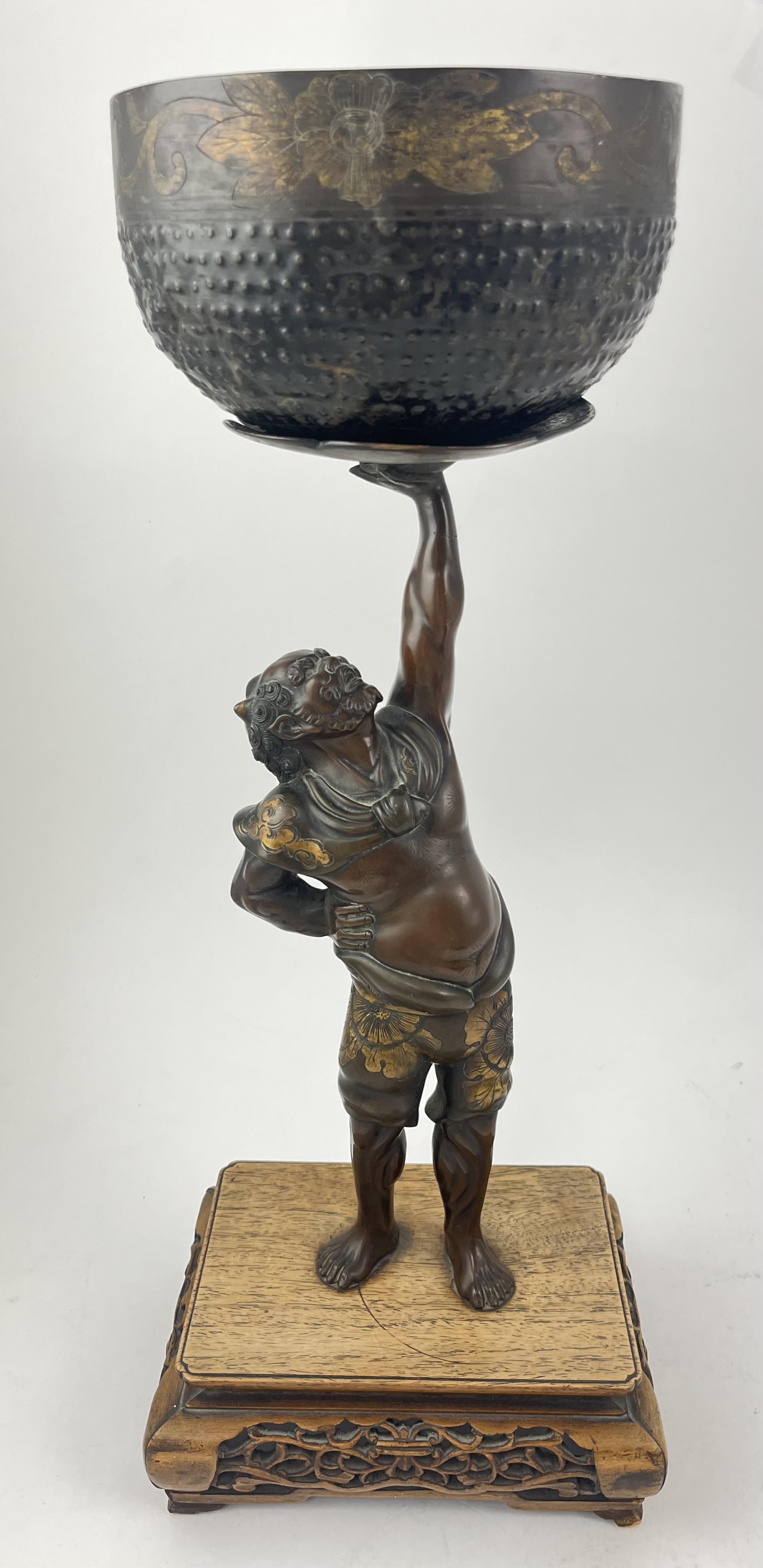A Japanese bronze figure of an Oni holding a temple bell aloft, Meiji period, in Miyao style